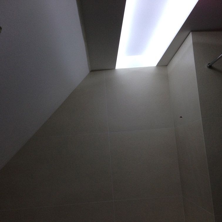 Une pièce sombre avec une lumière qui brille à travers le plafond