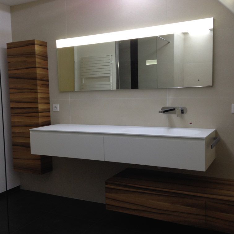 Une salle de bain avec un grand miroir et un lavabo