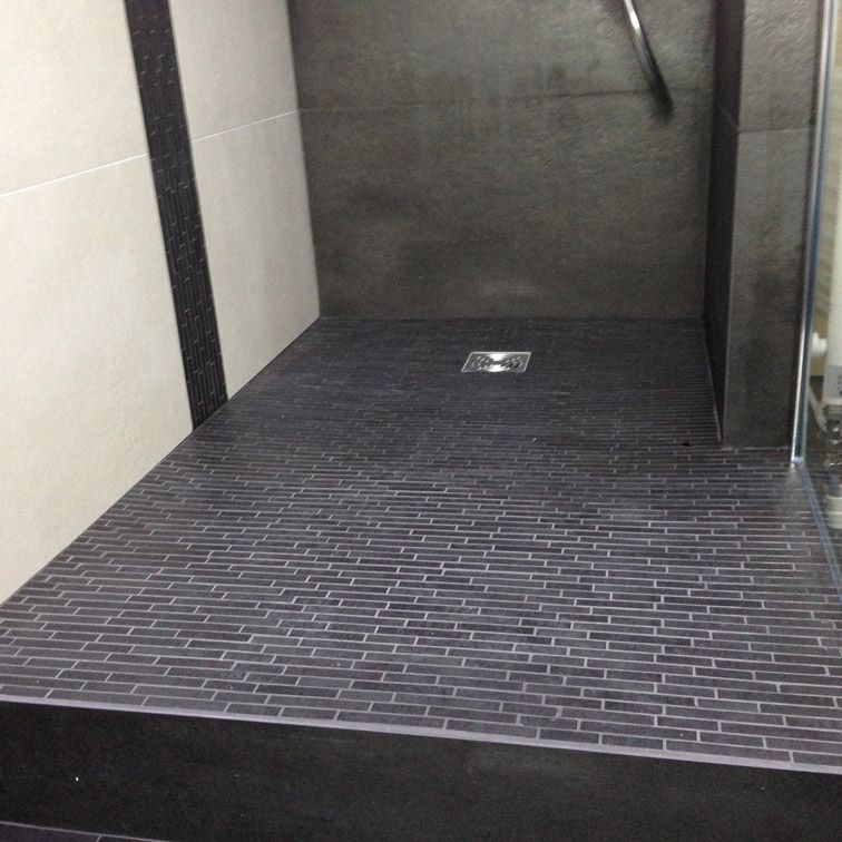 Une douche à l'italienne avec un sol en carrelage noir