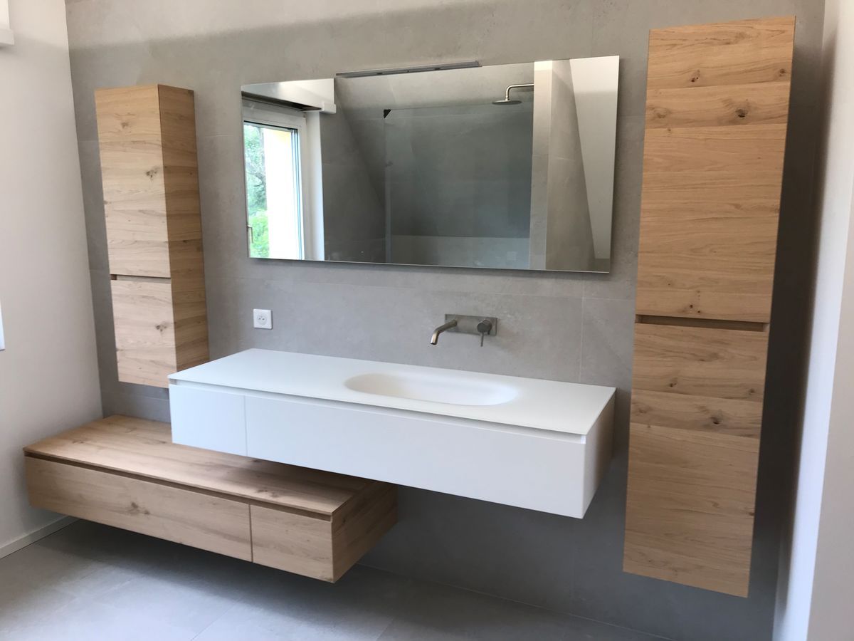 Une salle de bain avec un lavabo, un miroir et des armoires en bois