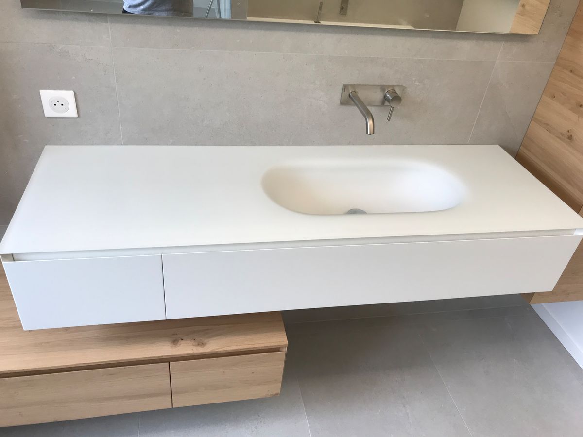 Une salle de bain avec un lavabo blanc et un miroir