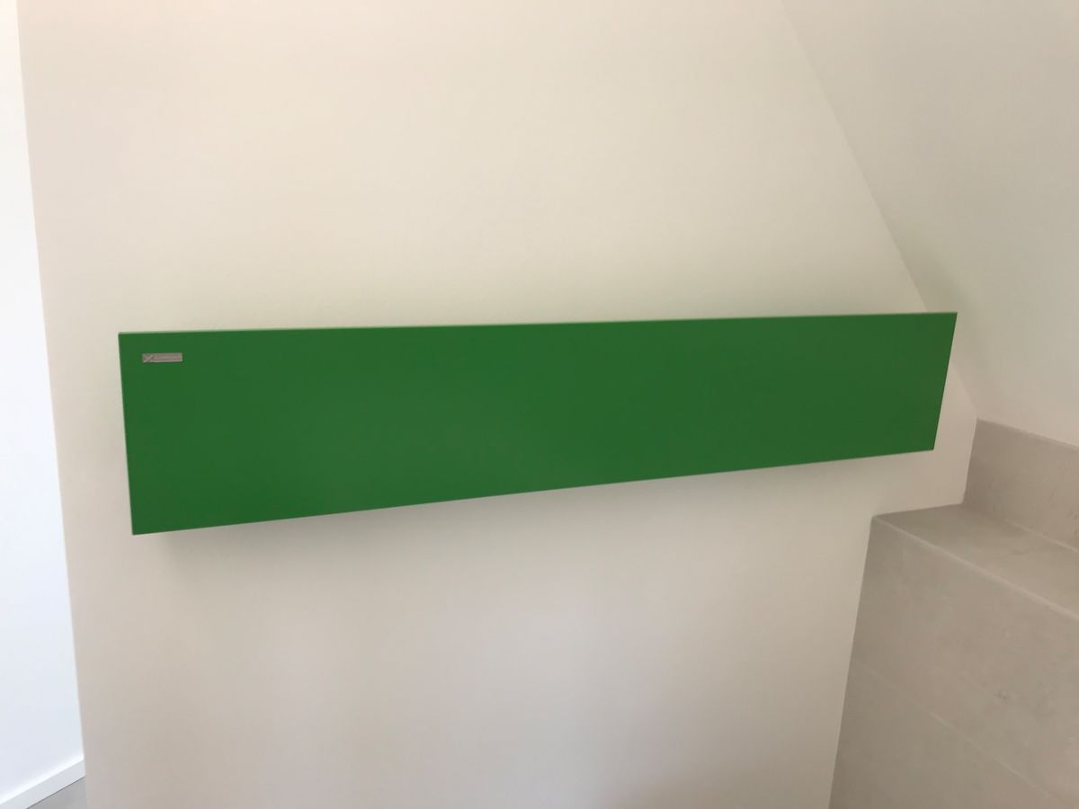 Un tableau vert est accroché sur un mur blanc