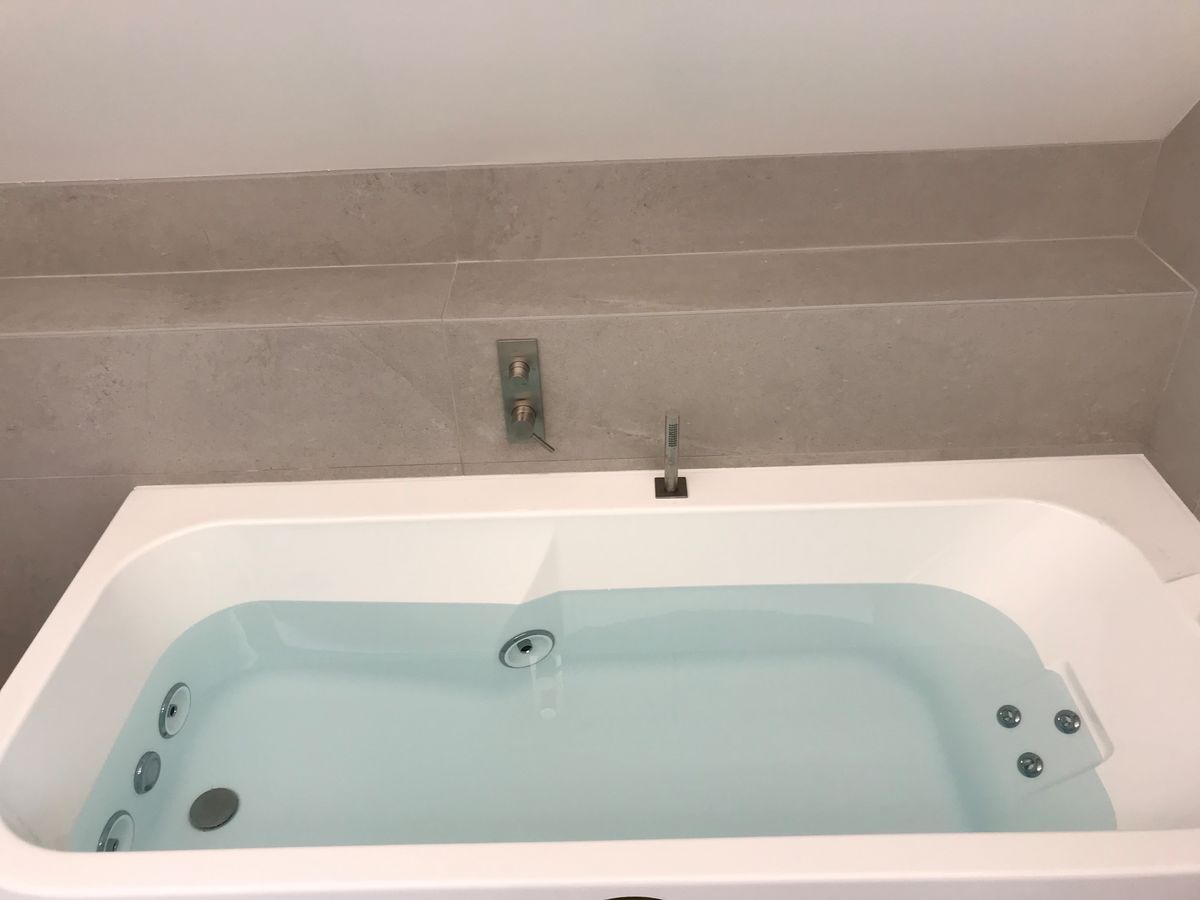 Une baignoire remplie d'eau bleue dans une salle de bain