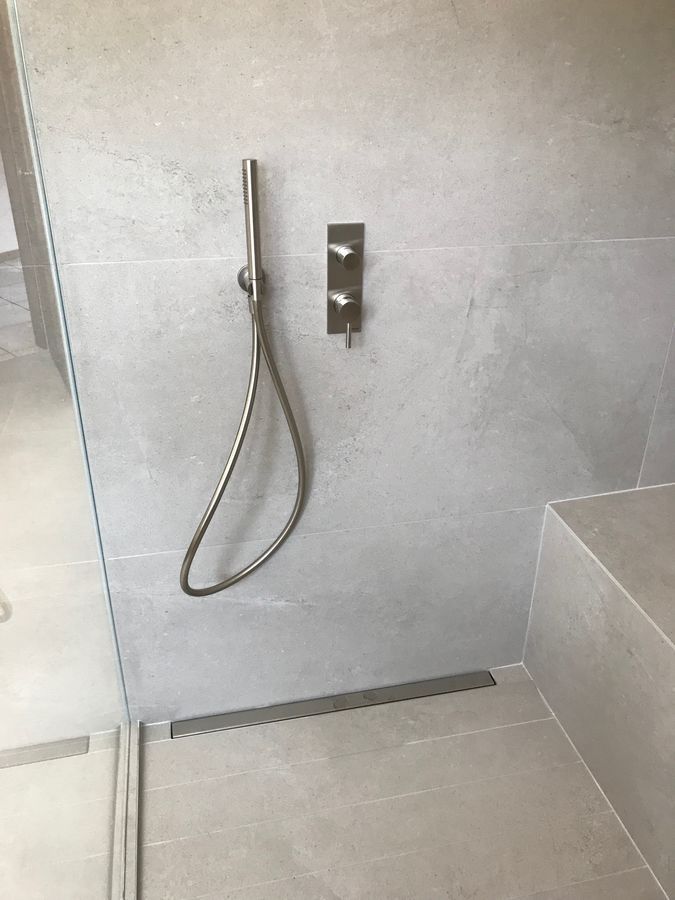 Une pomme de douche est suspendue au mur dans une salle de bain.