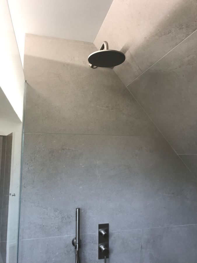 Une pomme de douche est suspendue au plafond d'une salle de bain.