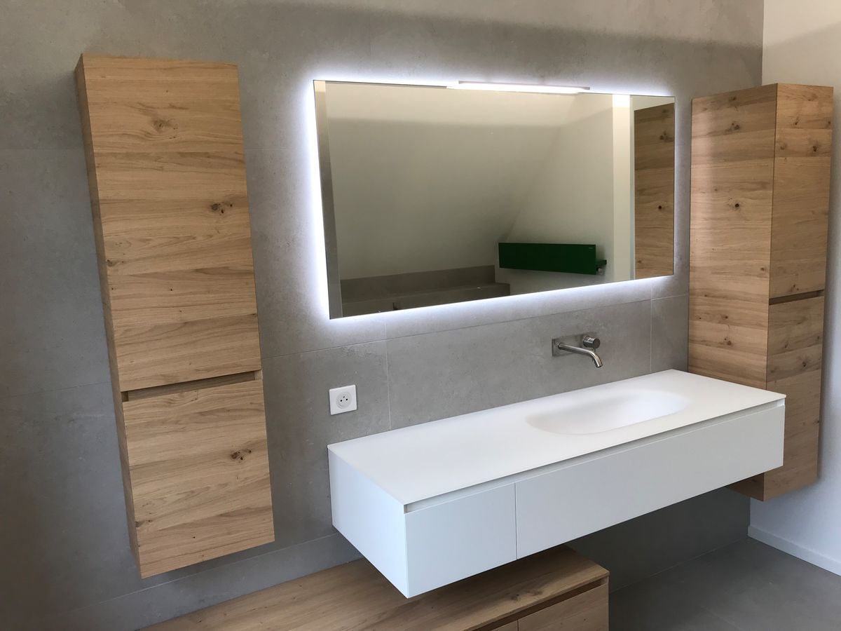 Une salle de bain avec un lavabo, un miroir et des armoires en bois