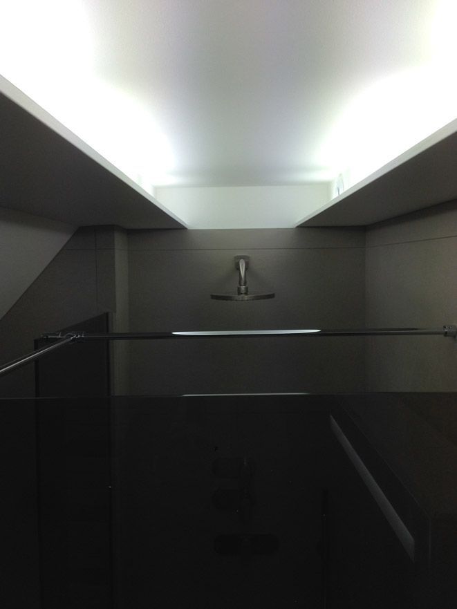 Une pièce sombre avec une lumière au plafond et des escaliers.