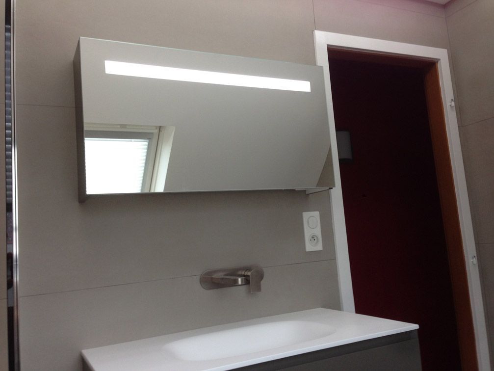 Une salle de bain avec un lavabo, un miroir et une porte