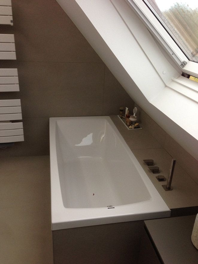 Une baignoire dans une salle de bain avec un puits de lumière au-dessus