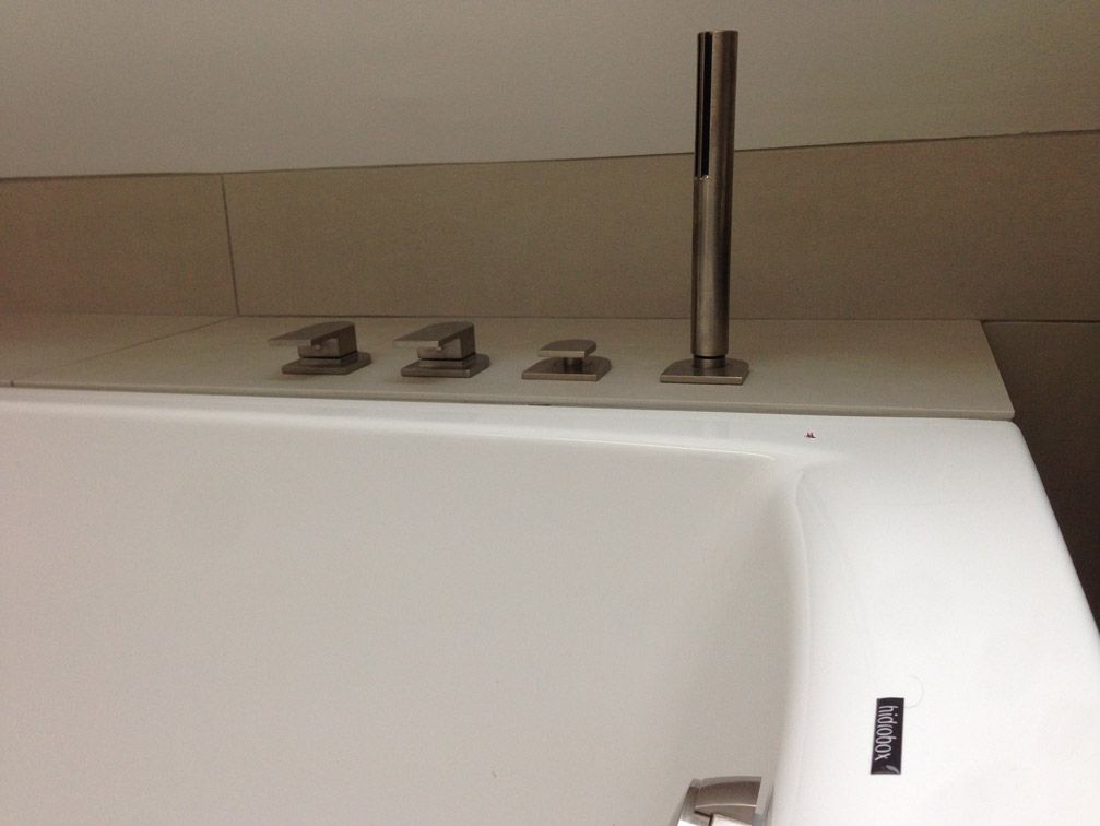 Une baignoire blanche avec une pomme de douche en acier inoxydable