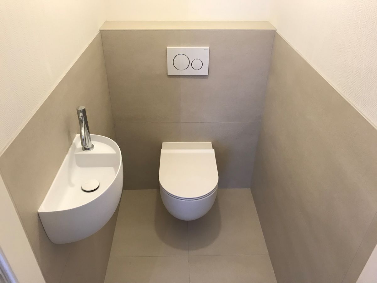 Une petite salle de bain avec toilettes et lavabo