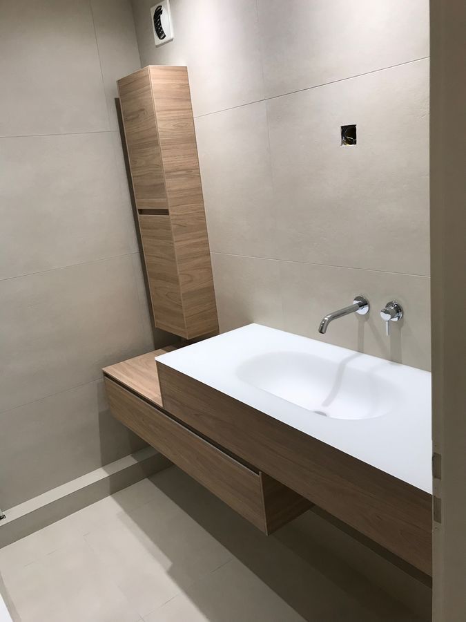 Une salle de bain avec un lavabo et un meuble en bois