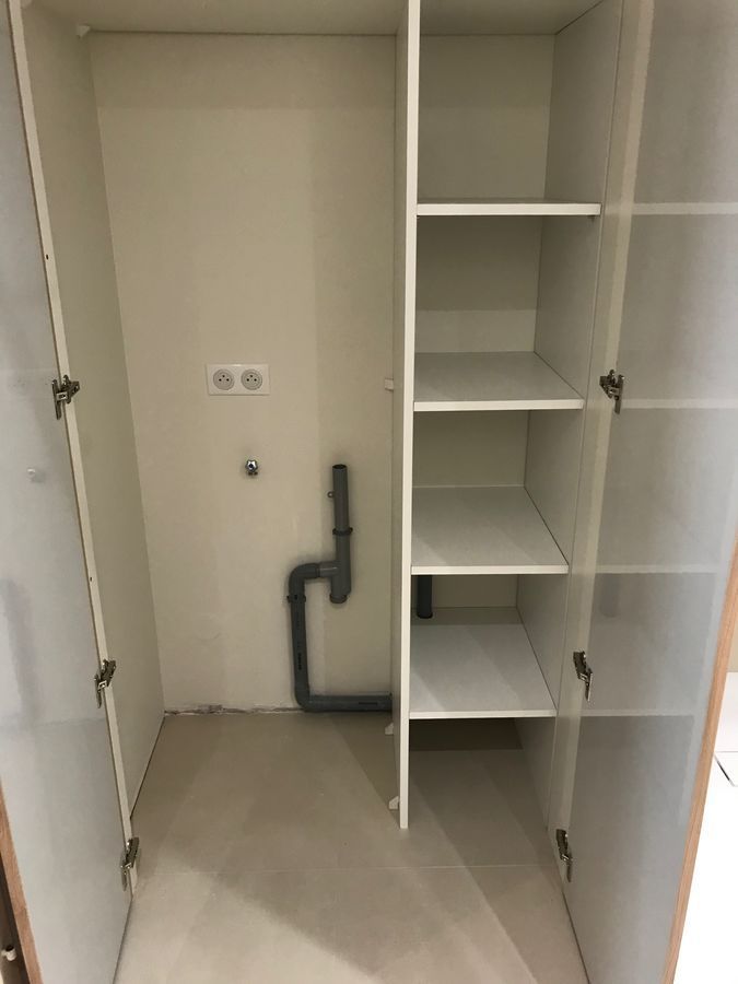 Un placard avec des étagères et un tuyau dedans.