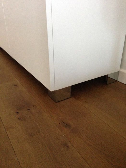 Un gros plan d'une armoire blanche sur un plancher en bois.