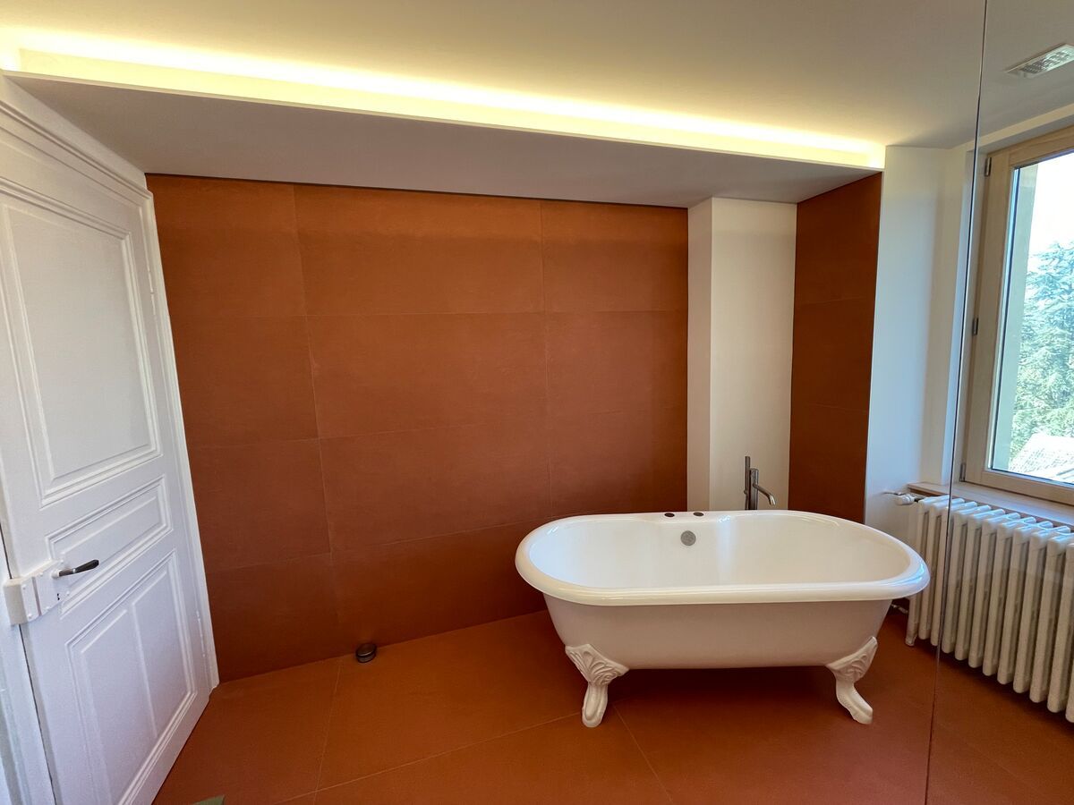 Une salle de bain avec baignoire et radiateur.