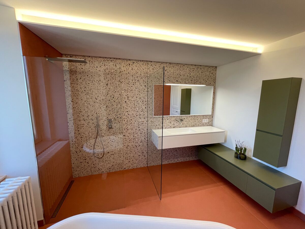 Une salle de bain avec baignoire, lavabo, miroir et douche à l'italienne.