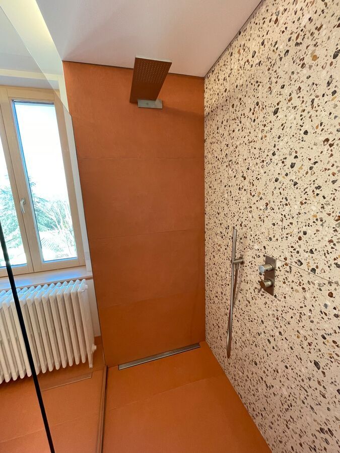Une salle de bain avec douche à l'italienne et fenêtre.