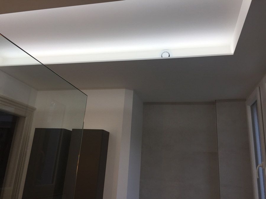 Une salle de bain avec un miroir et une lumière au plafond