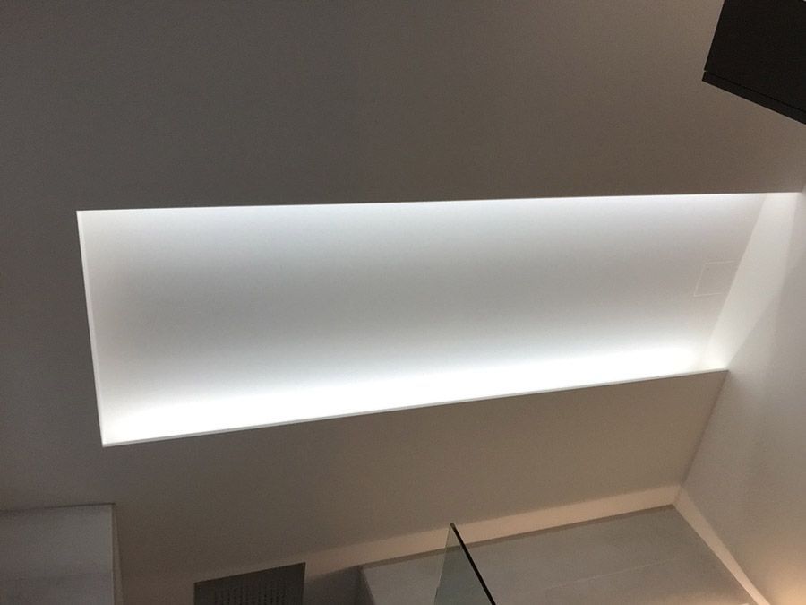 Un plafond blanc d'où sort une lumière.