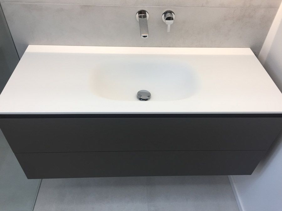 Un lavabo de salle de bain avec un robinet et deux tiroirs en dessous.