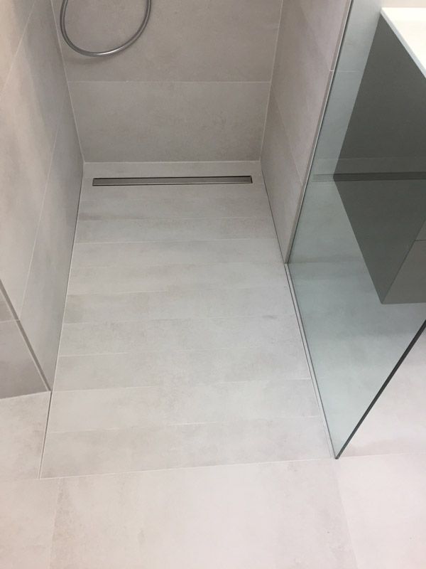 Une salle de bain avec une douche à l'italienne et un lavabo.