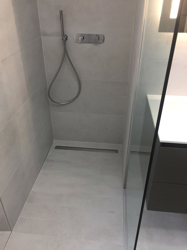Une salle de bain avec une douche à l'italienne et un lavabo.