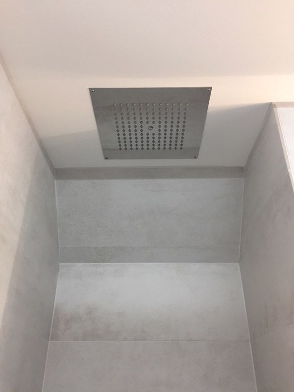 Une pomme de douche est suspendue au plafond d'une salle de bain.