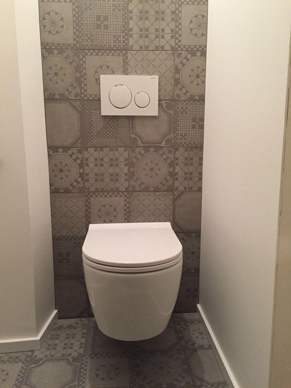 Une toilette est accrochée au mur d'une salle de bain.