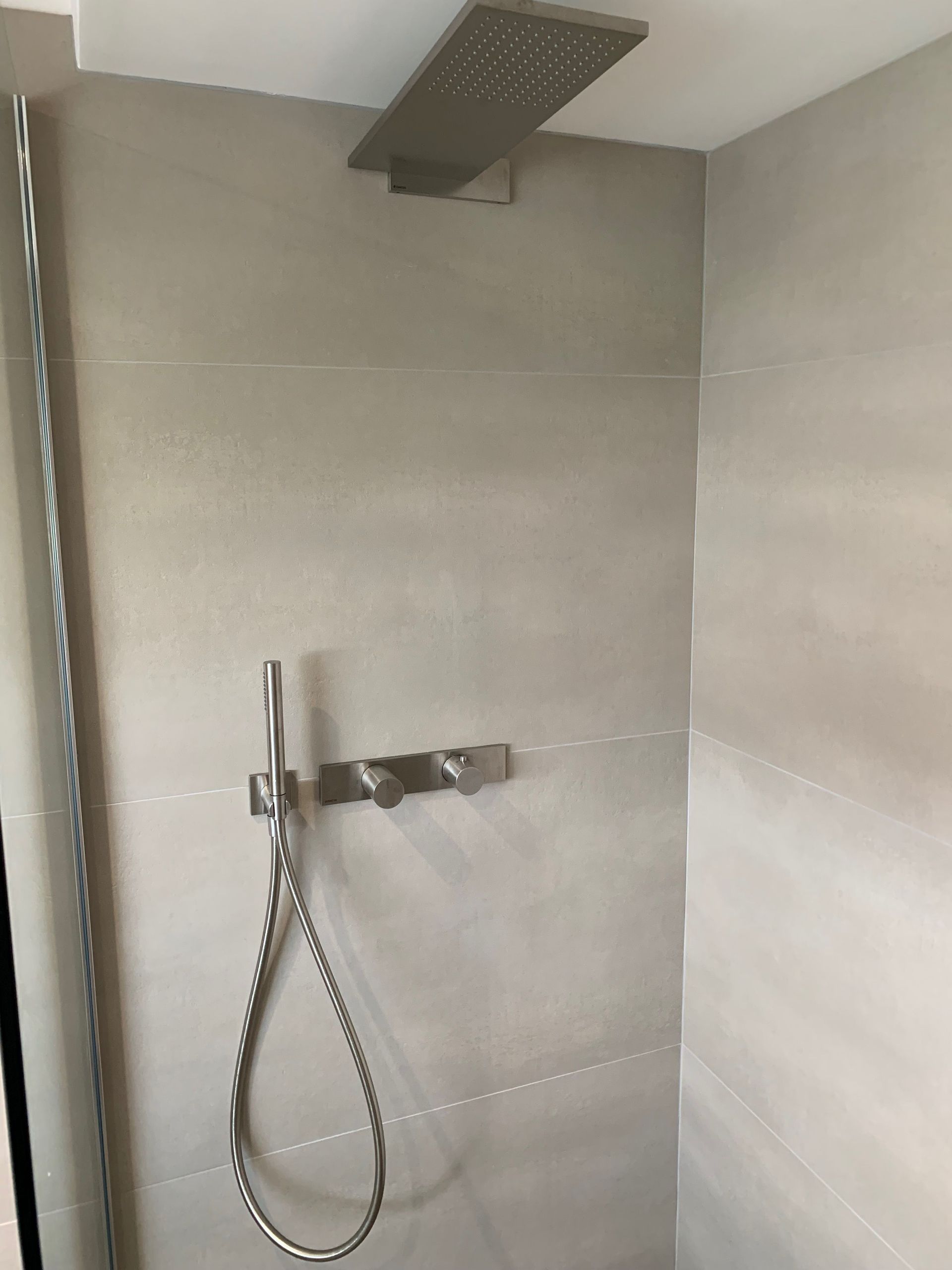 Une pomme de douche est suspendue au plafond dans une salle de bain