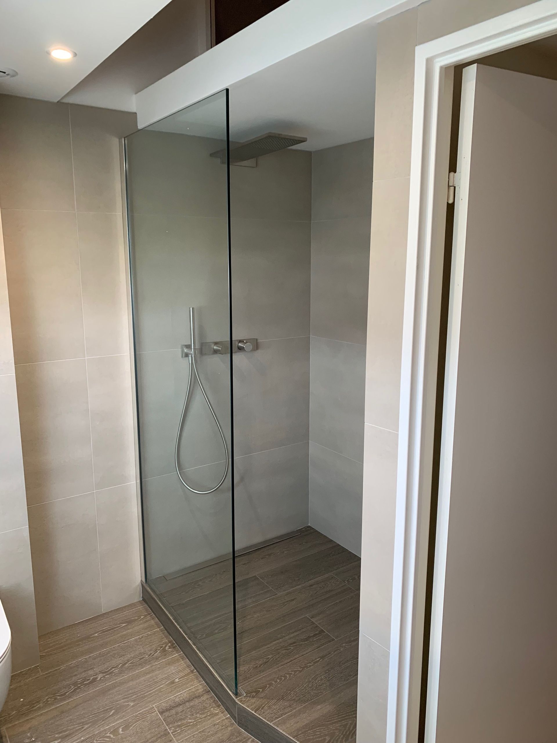 Une salle de bain avec douche à l'italienne et WC.