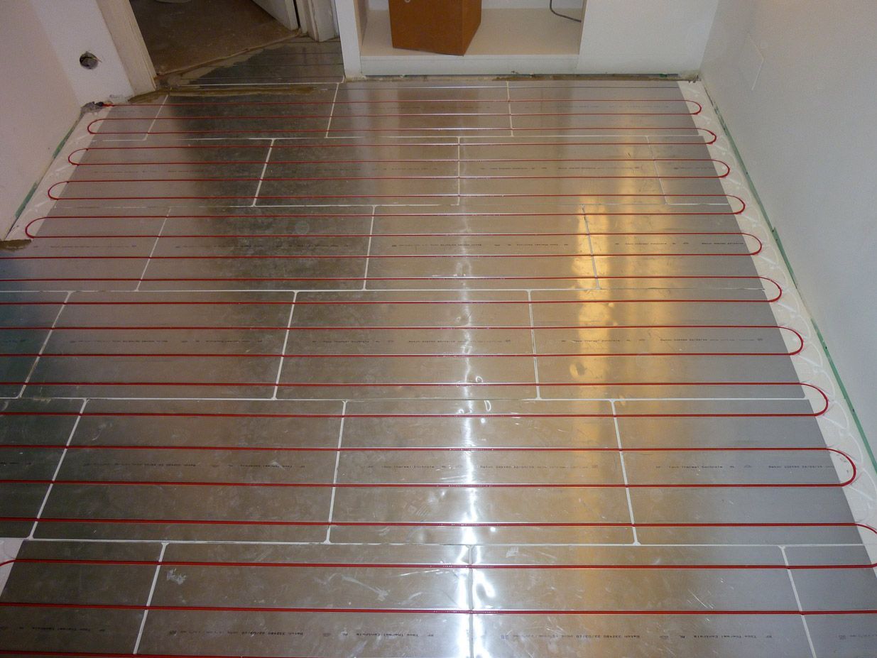 Un sol en acier inoxydable traversé par des fils rouges