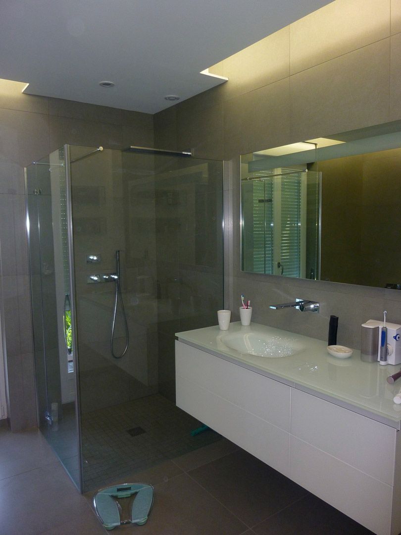 Une salle de bain avec un lavabo, un miroir et une douche à l'italienne