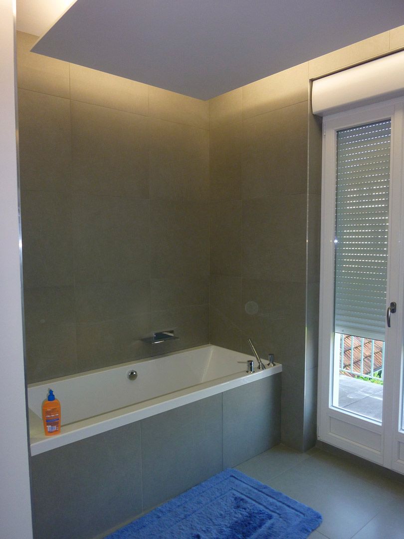 Une salle de bain avec une baignoire et un tapis bleu