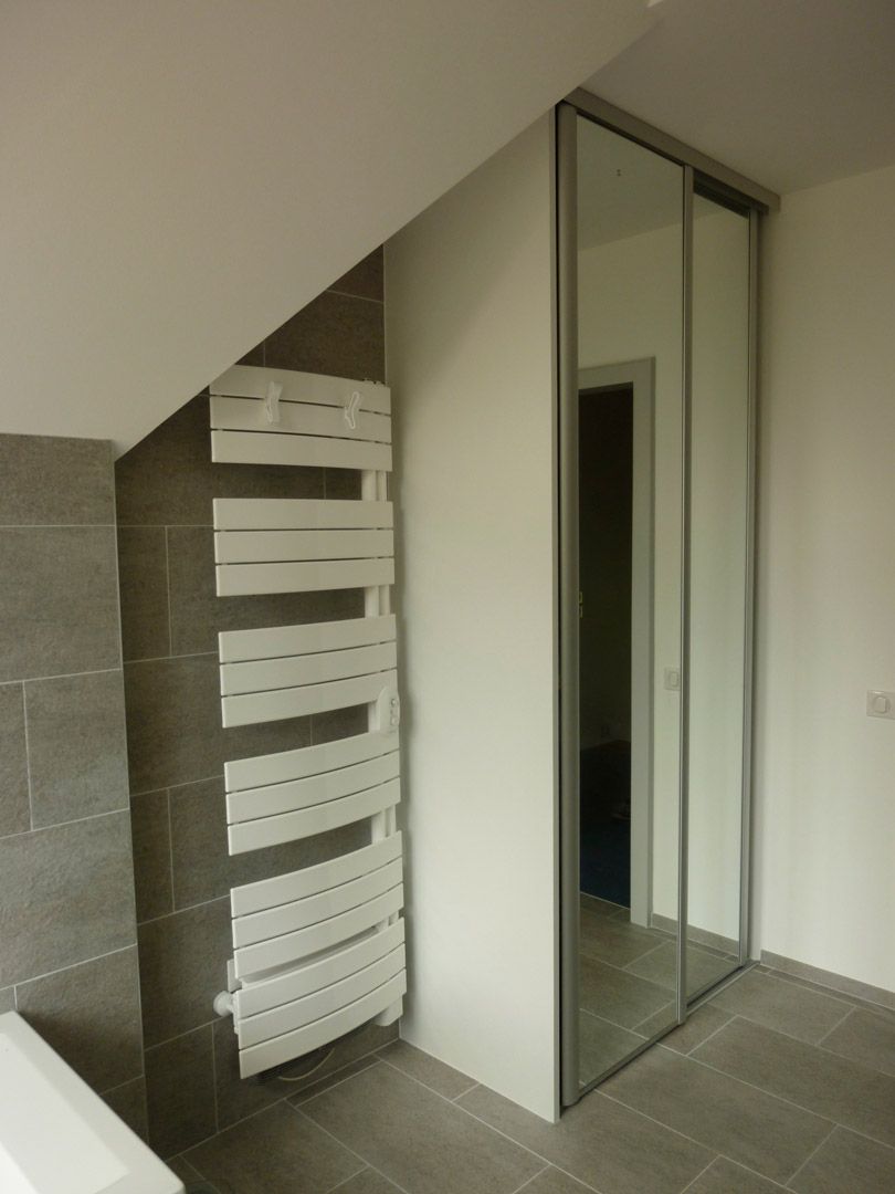 Une salle de bain avec un porte-serviettes et un miroir