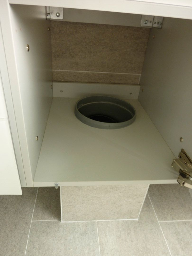 Une armoire blanche avec un trou au milieu.