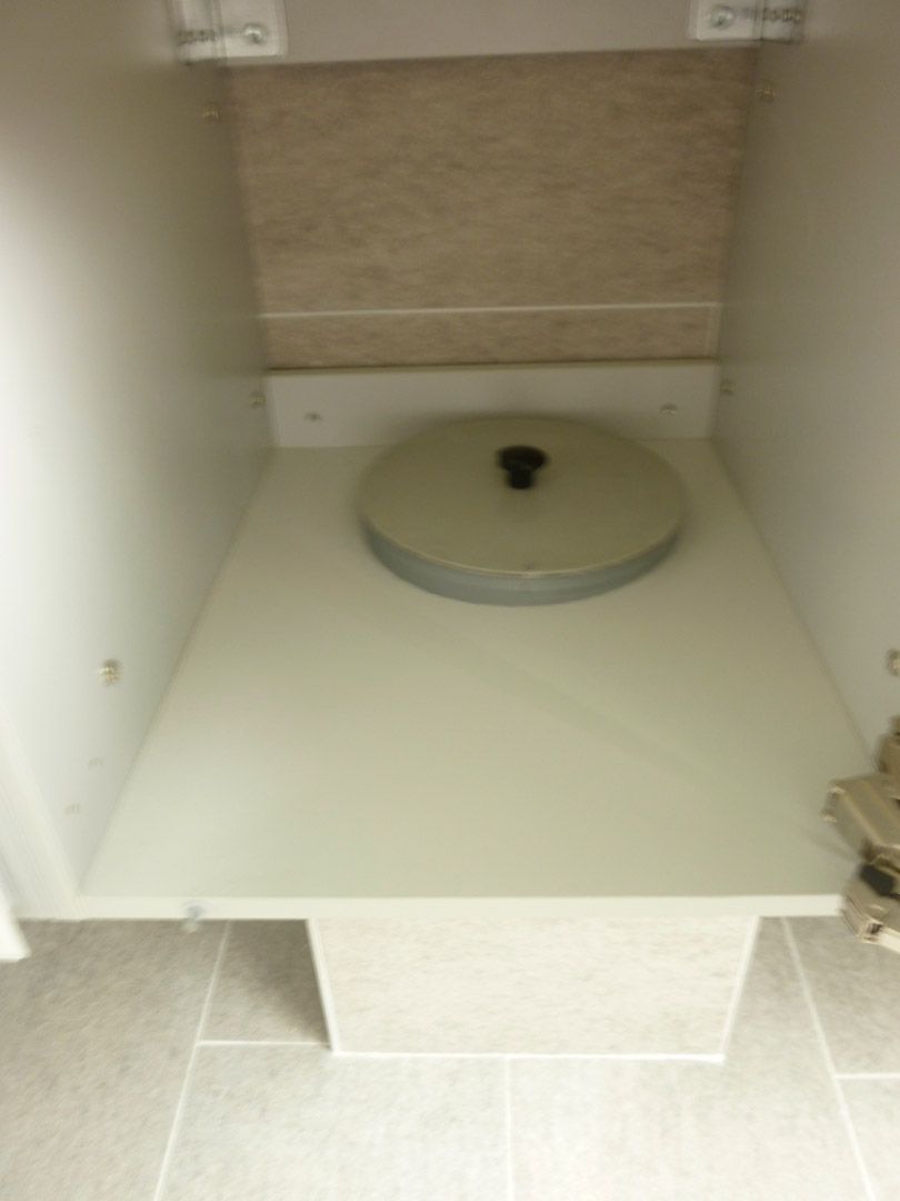 Un comptoir blanc avec un couvercle dessus dans une salle de bain.