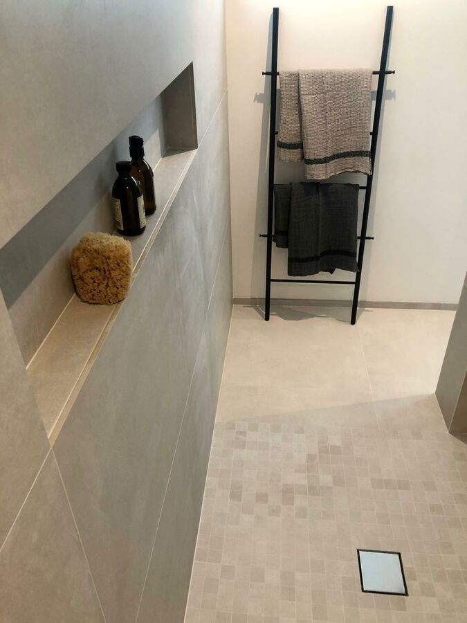 Une salle de bain avec une échelle et des serviettes dessus