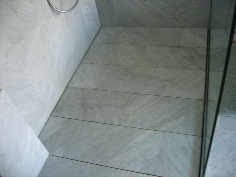 Une salle de bain avec une douche à l'italienne et un miroir