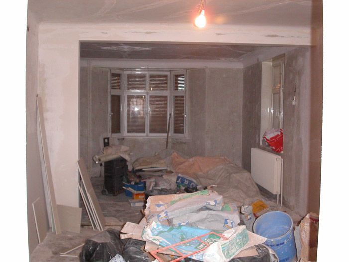 Une pièce en cours de rénovation avec beaucoup de déchets sur le sol
