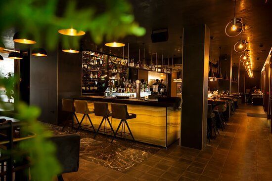 A restaurant with a bar and tables and chairs