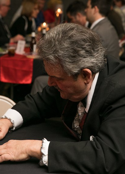 A man in a suit and tie is sitting at a table