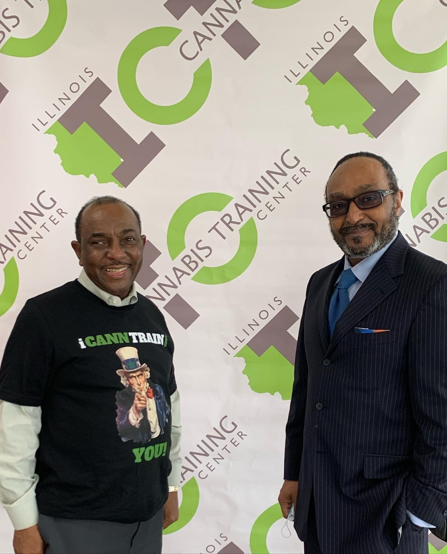 Two men standing in front of a sign that says illinois training center