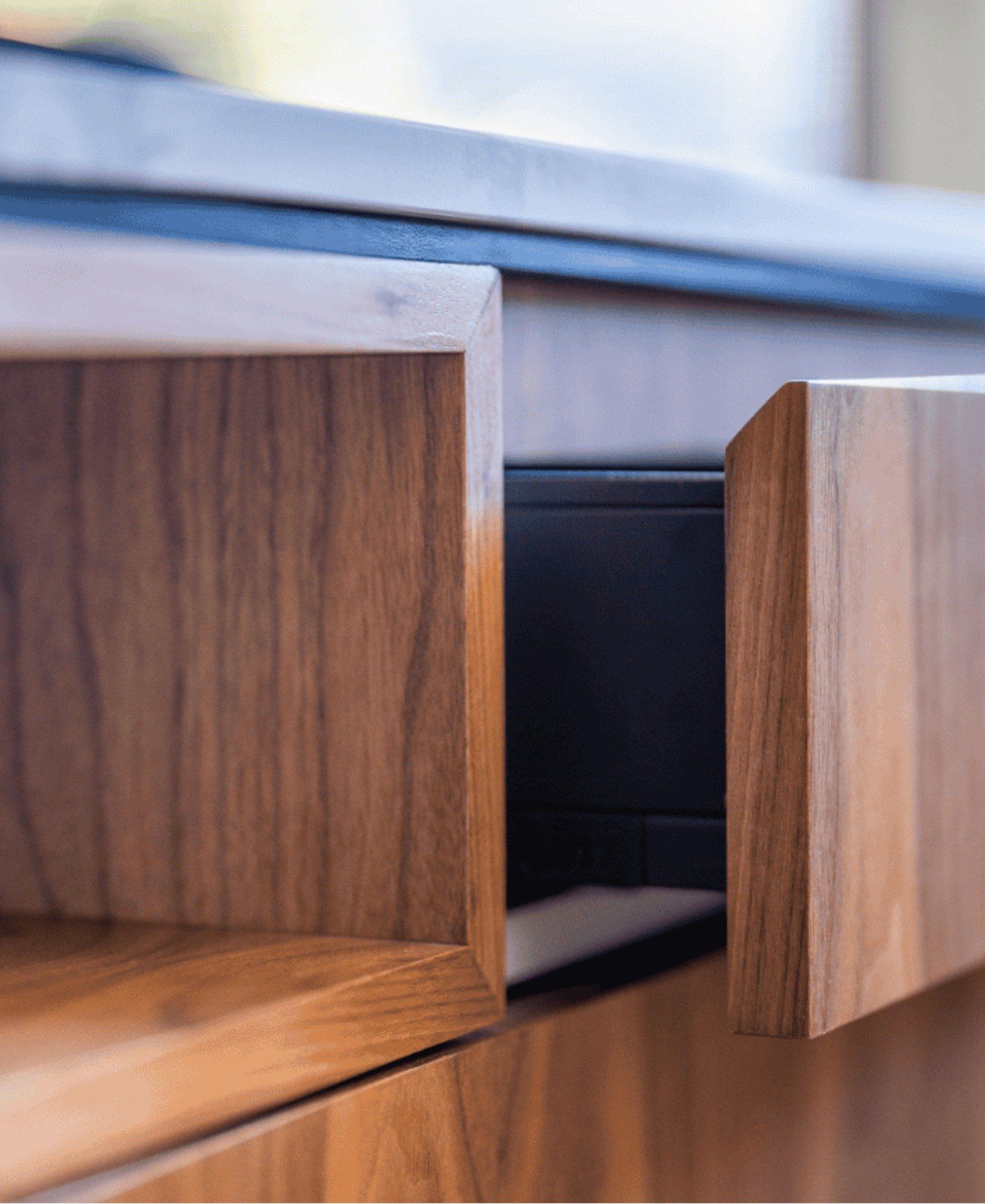 A close up of a wooden drawer with the drawer open.