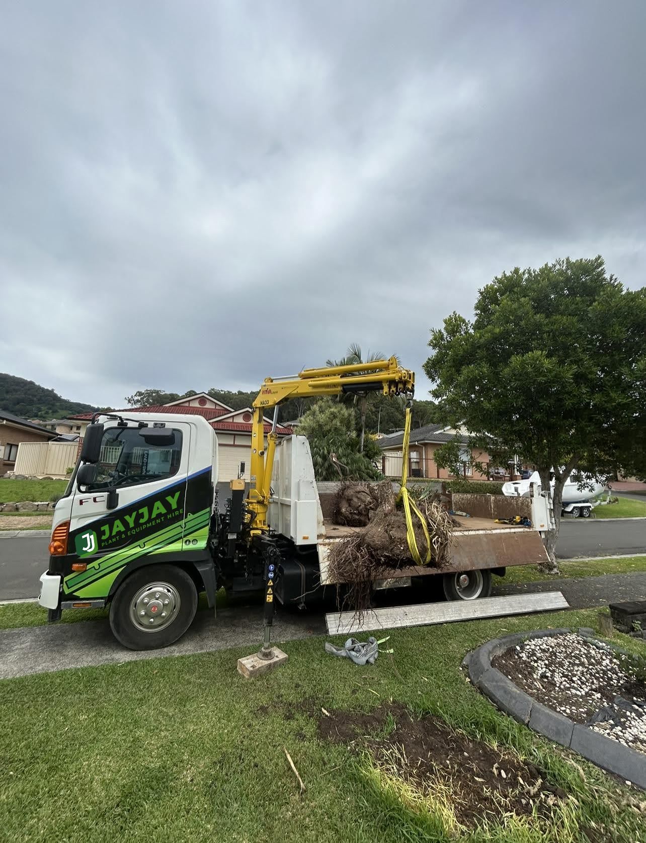 crane truck lifting a block of dirt