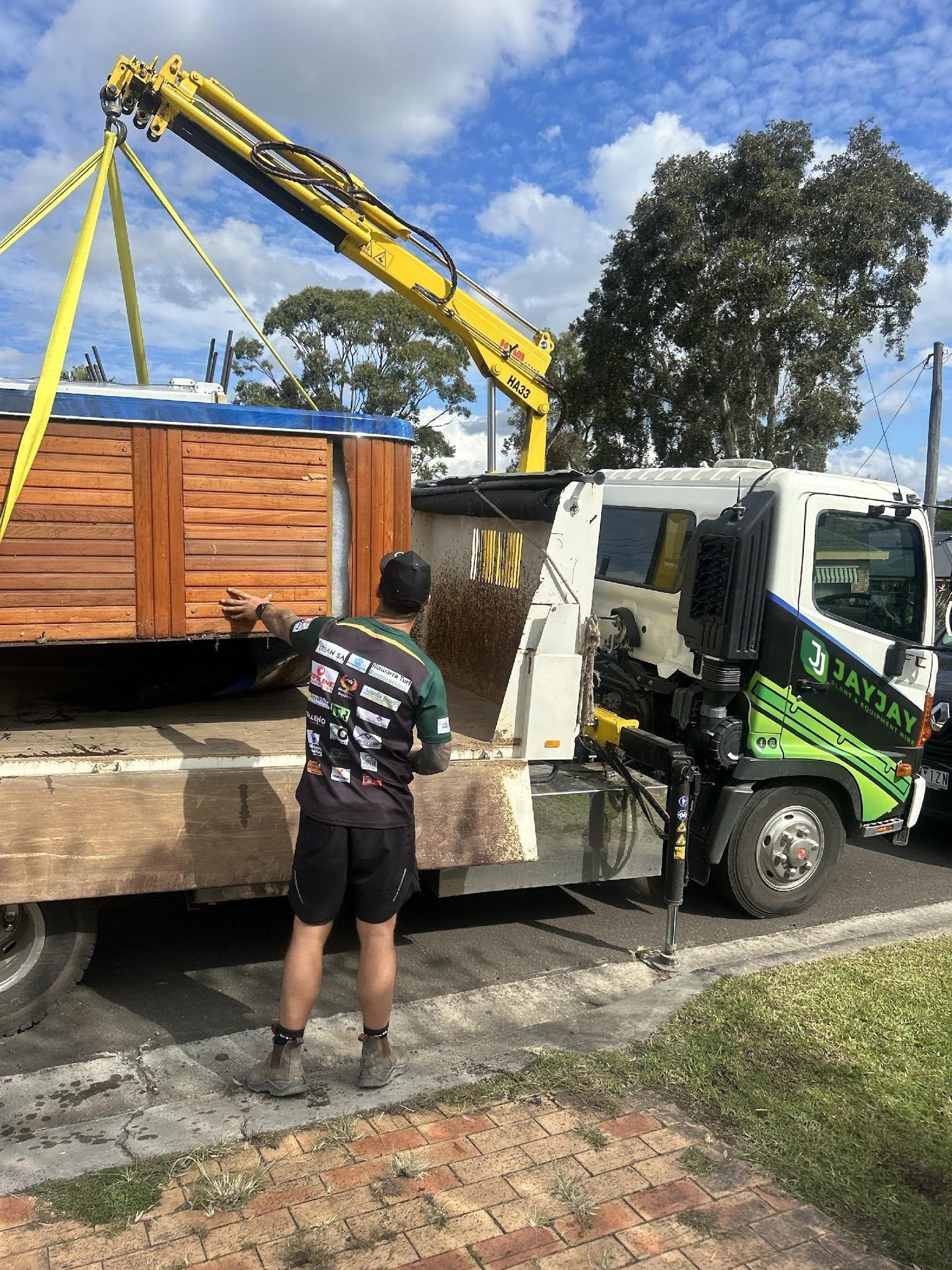 a man is standing next to a truck with a crane attached to it