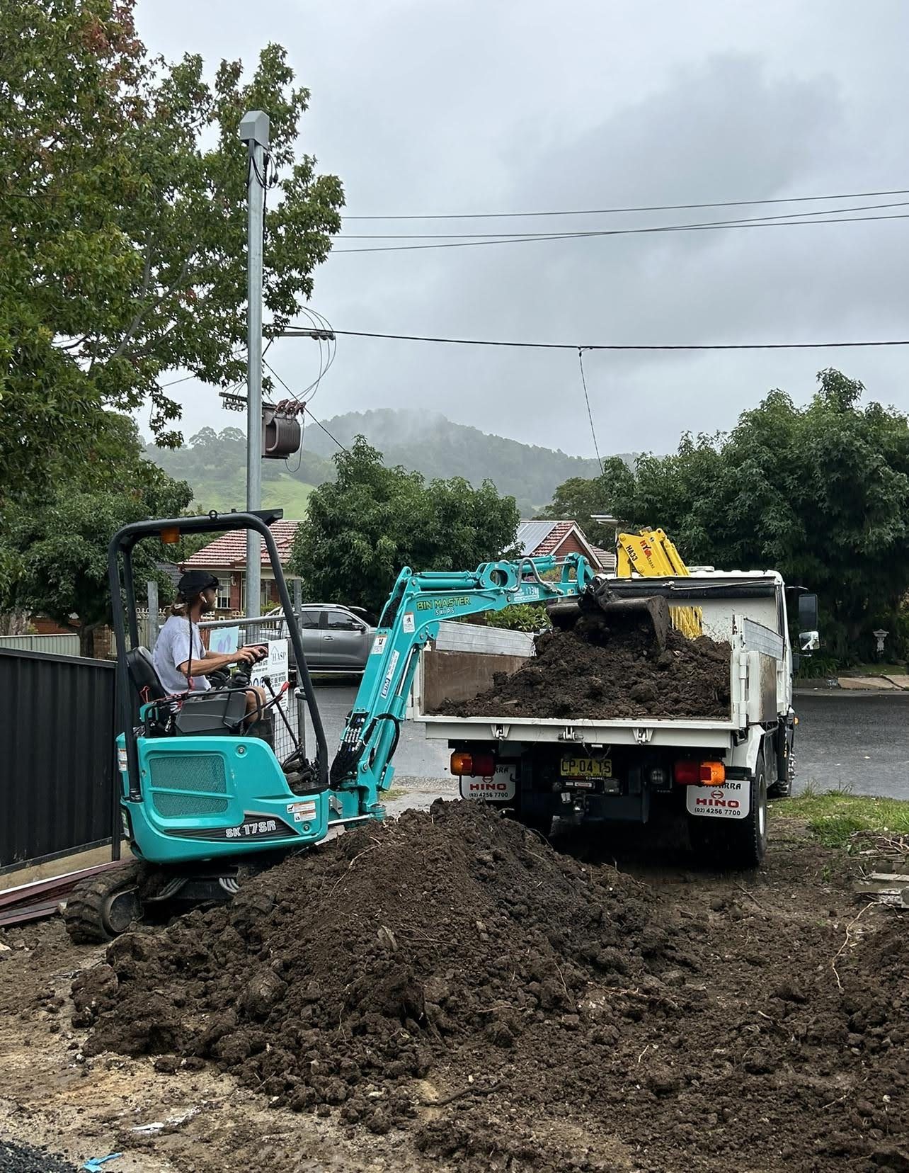 mini excavator loading dirt in truck