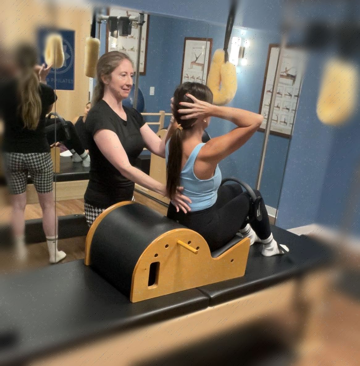 Eve Salazar giving Pilates instruction for Pilates Teacher Training on the Small Barrel also called the Pilates Spine Corrector