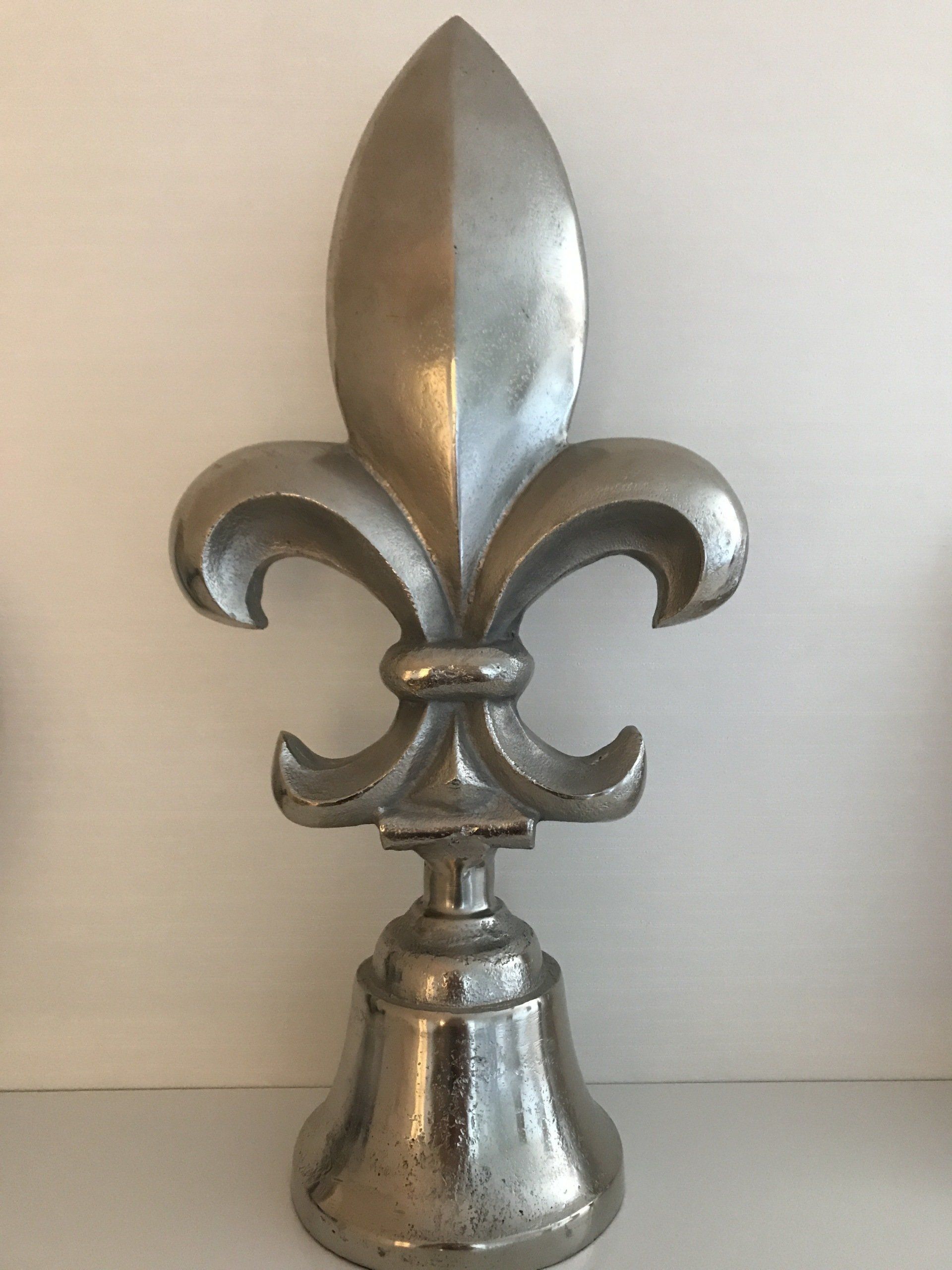 Eine silberne Statue einer Lilie sitzt auf einem Tisch