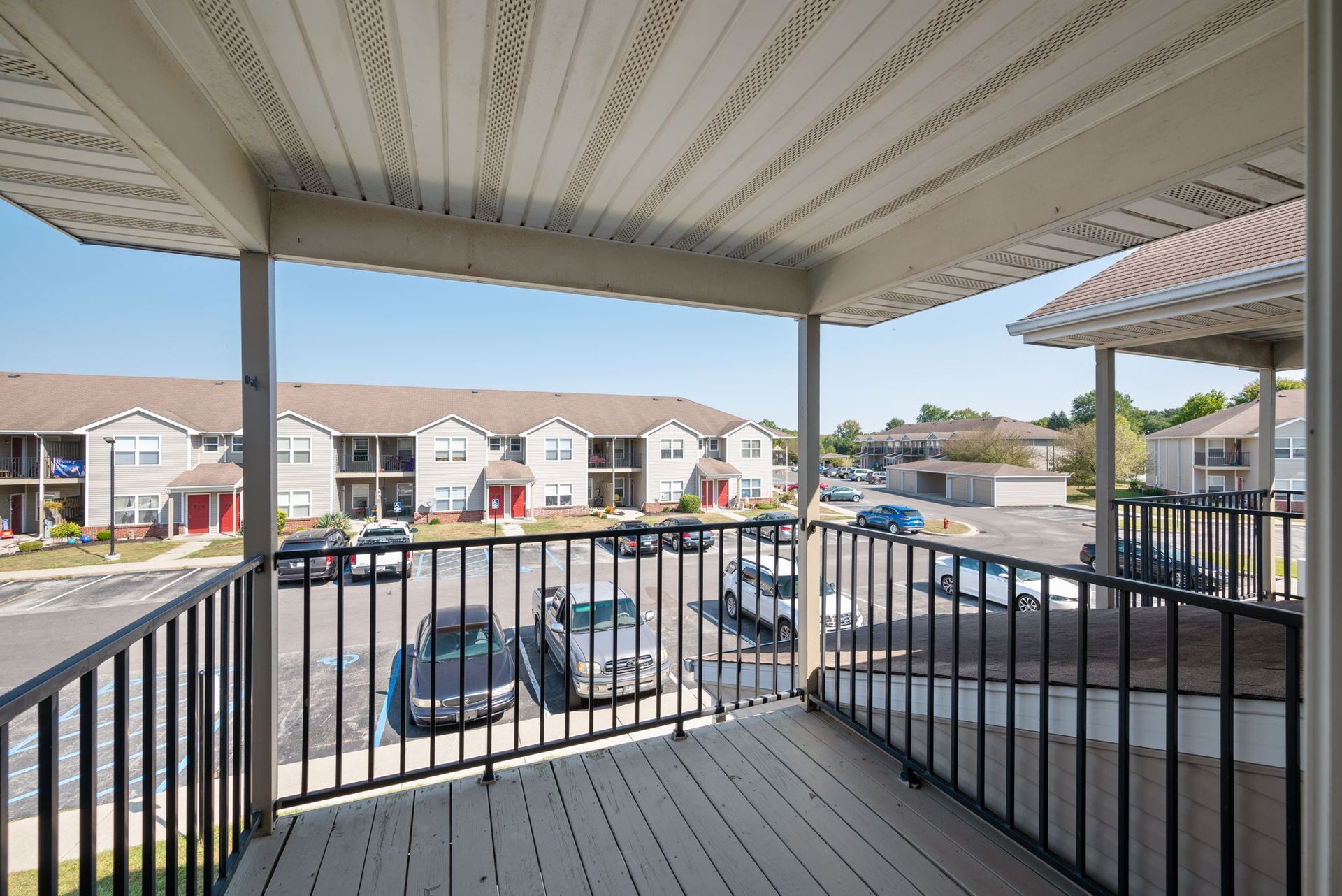A balcony overlooking a parking lot.