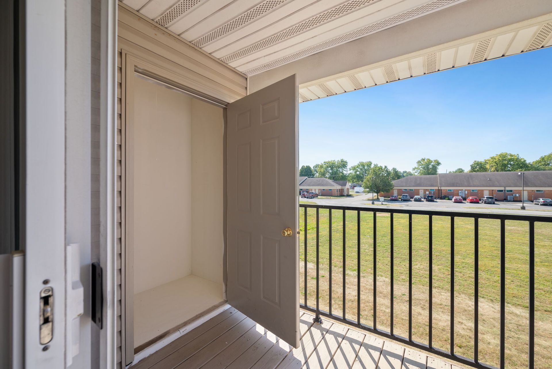 A balcony with a sliding glass door and a metal railing.